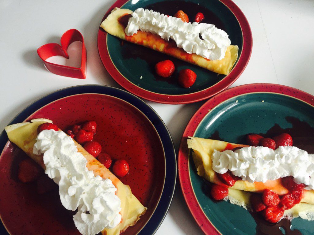 Cheesecake Filled Crepes with Strawberry Sauce and Whipped Cream