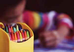 Kid coloring with crayons